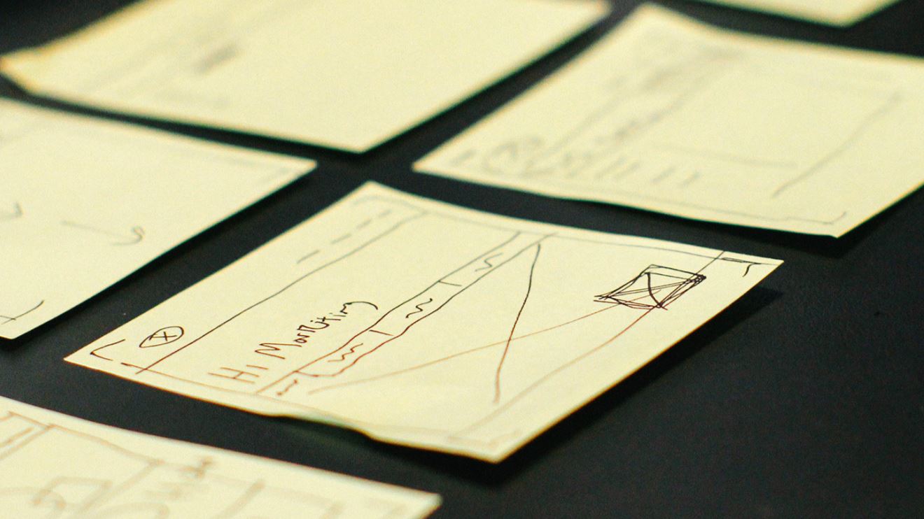Sticky notes laid out with wireframes drawn on them