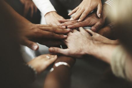 A picture of hands coming together in a circle