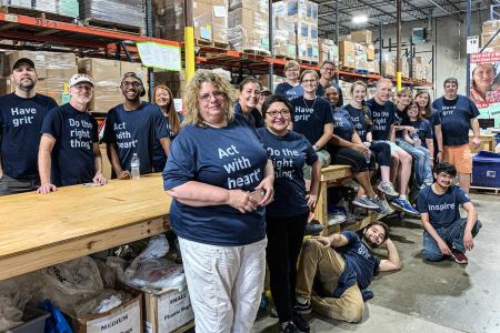 The BrandExtract team standing against tables at Project C.U.R.E. trailer.