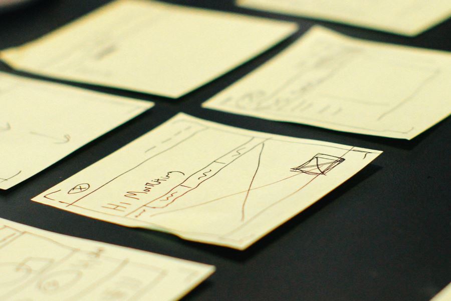 Sticky notes laid out with wireframes drawn on them