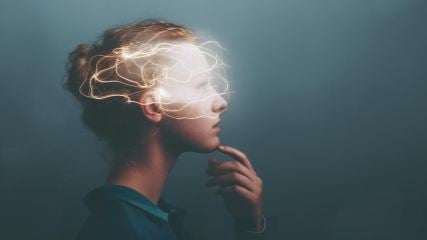 A woman in a thoughtful pose with lights dancing around her head