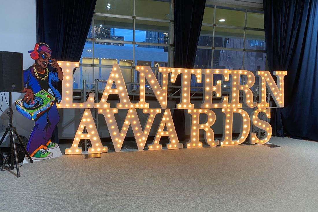 Photograph of large light-up letters spelling "Lantern Awards" against a window