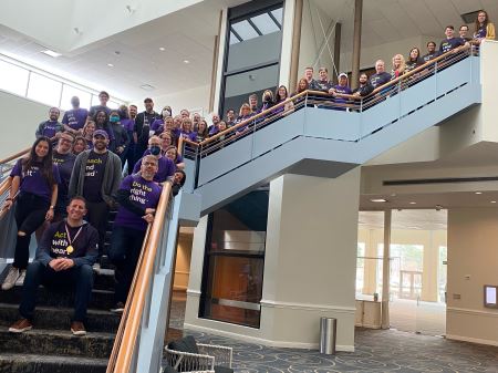 Entire BE team standing together on a staircase