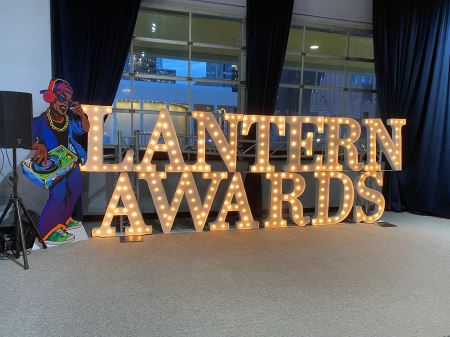 Photograph of large light-up letters spelling "Lantern Awards" against a window