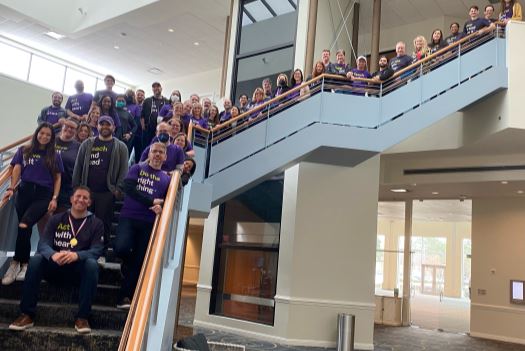 Entire BE team standing together on a staircase