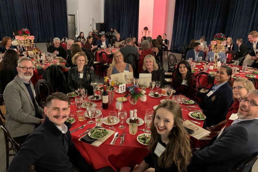 A group of ten BrandExtract employees sitting around a large round table at the Lantern Awards gala