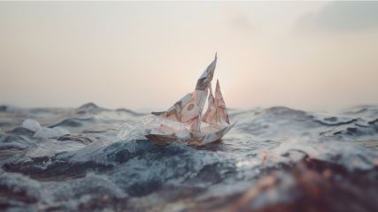 Sailboat on rough waters with sun in background.