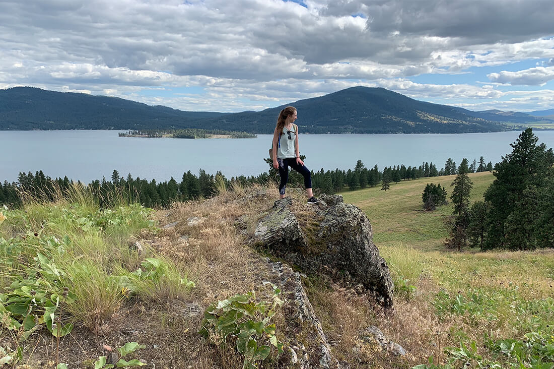 Woman posing in front of lake and mounstains