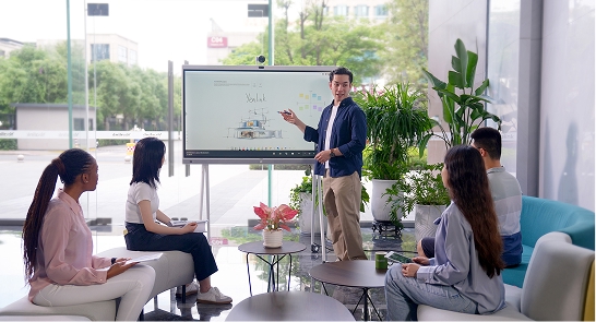 Diverse business team in modern conference room with instructor presenting at digital whiteboard