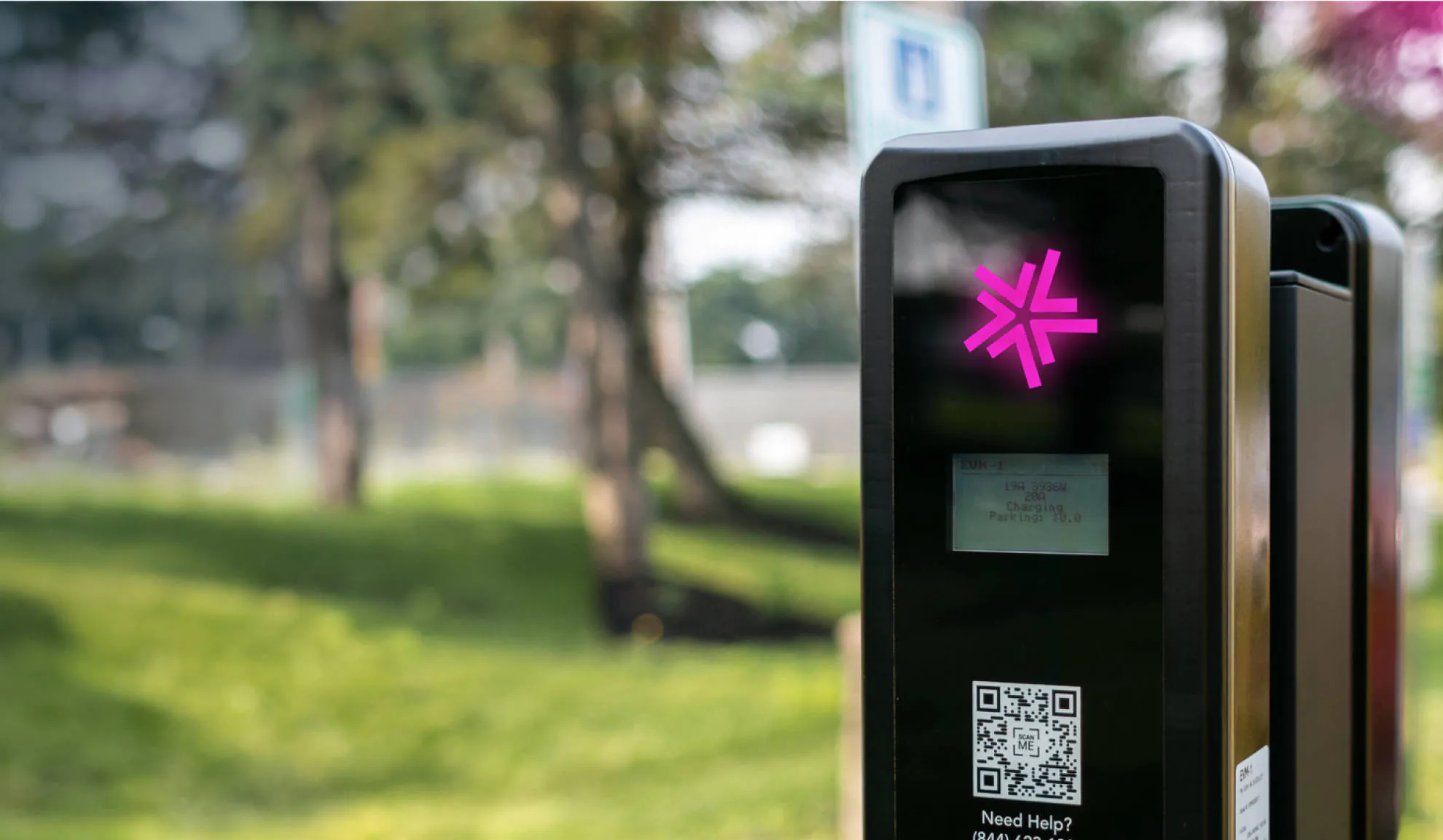 A Lynkwell charging station with the pink logo glowing