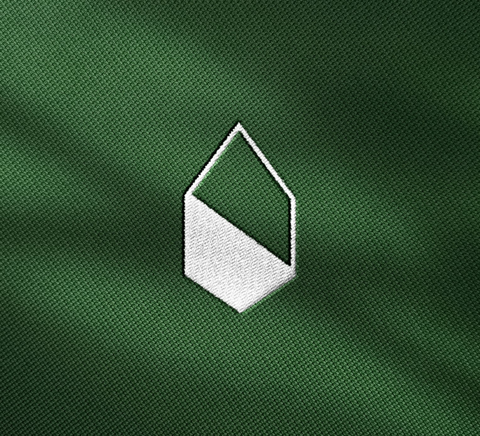 Milestone logo embroidered in white on green fabric.