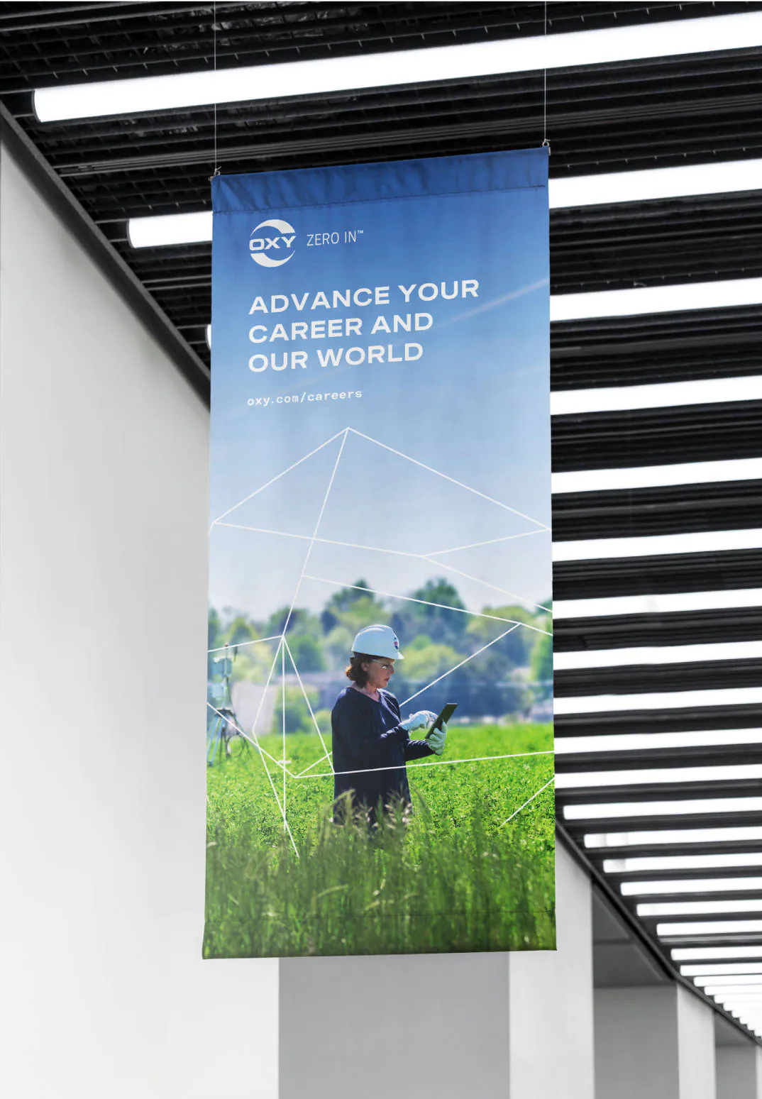 An Oxy banner hanging from the ceiling of a hallway, promoting career opportunities at Oxy