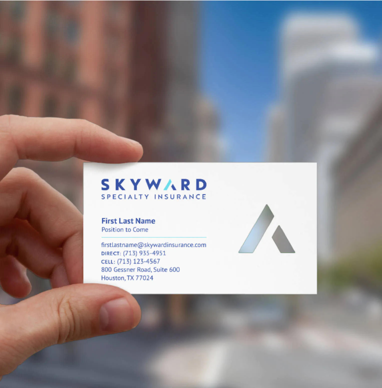 A hand holding an example of what a Skyward buisness card would look like in the new brand