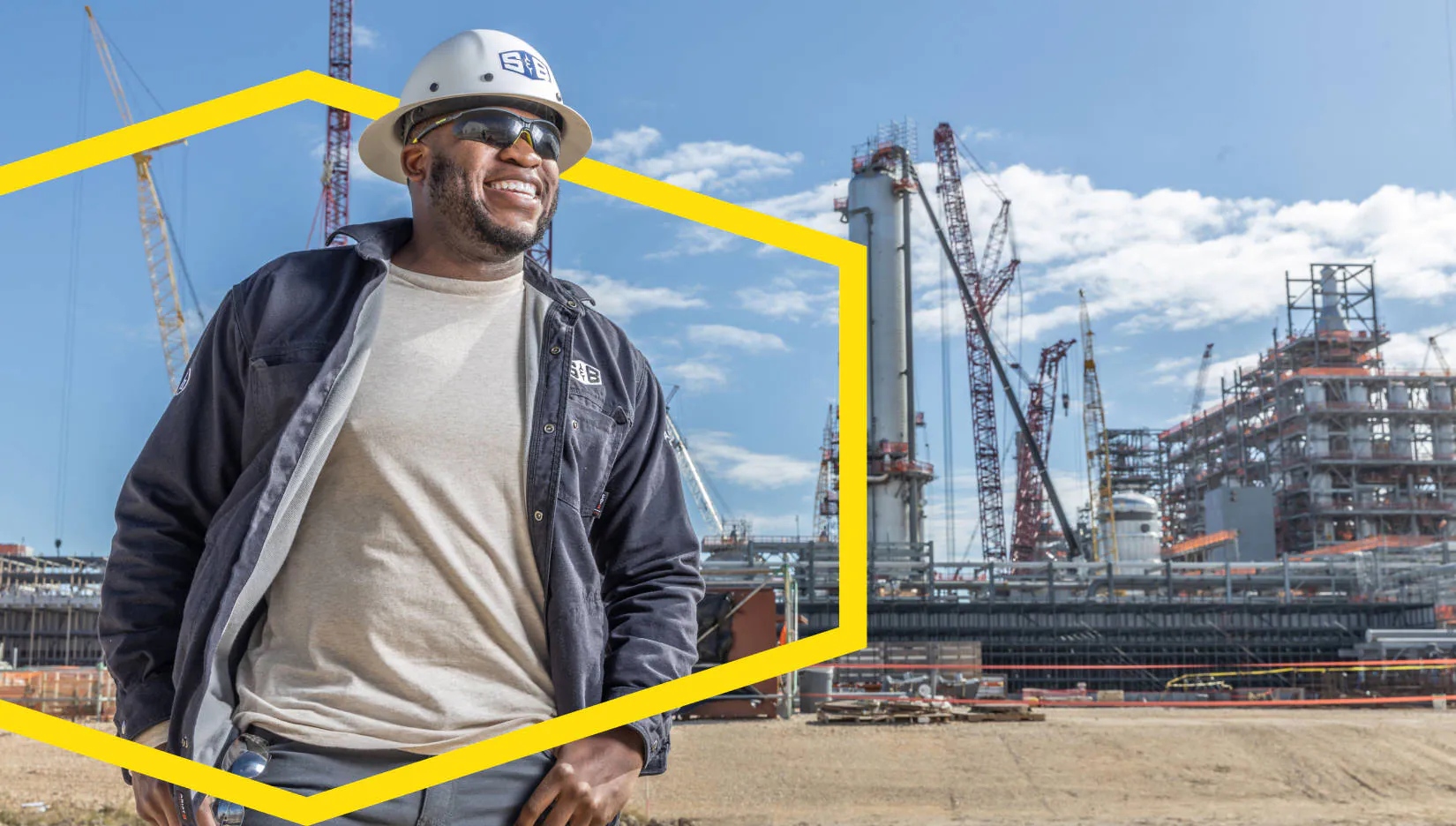 A S&B Employee shown smiling with a refinery in the background