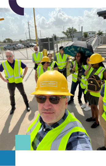 Group of BrandExtract team members taking a selfie wearing hardhats and safety vests before touring a client facility