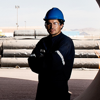 A GSE GSE employee posing outside near covered pipes.